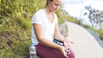Desportista com diabetes faz uma pausa no exercício para medir o açúcar no sangue